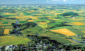 Aerial photograph of flat landscape with fields and a small village.