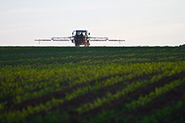 Picture of large tractor spraying pesticide on field.