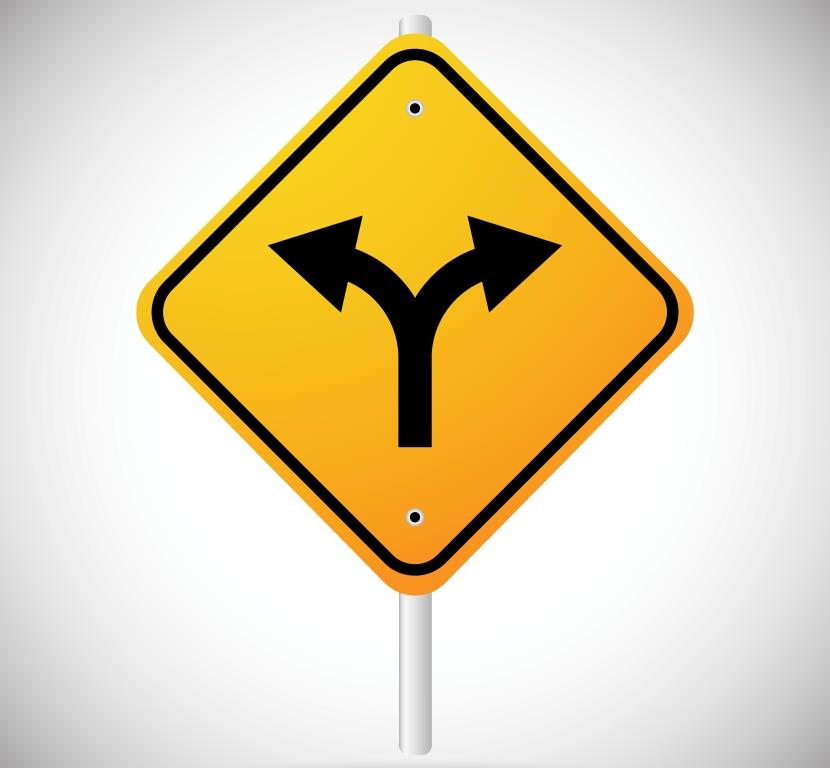 Yellow road sign displaying arrow that splits off to left and right.